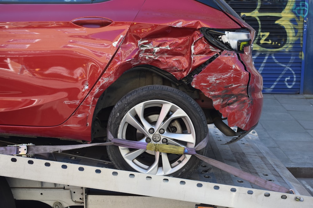 Accident-damaged car loaded on a flatbed tow truck